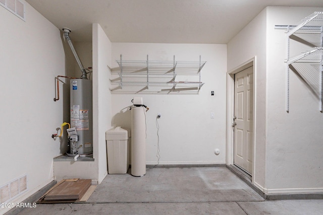 clothes washing area with gas water heater