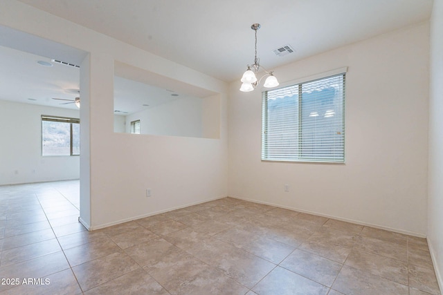 spare room featuring ceiling fan with notable chandelier and light tile patterned floors