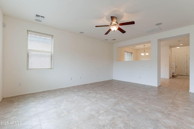 unfurnished room with ceiling fan with notable chandelier