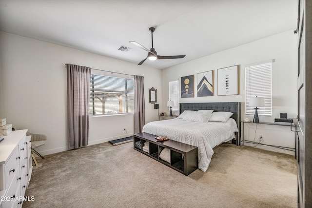 bedroom with visible vents, light carpet, baseboards, and a ceiling fan