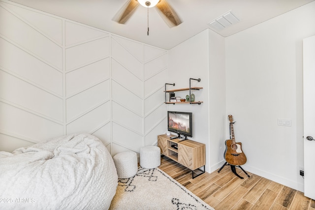 bedroom featuring baseboards, visible vents, light wood finished floors, and ceiling fan