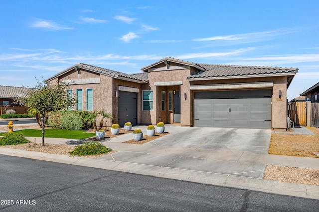 view of front facade featuring a tile roof, stucco siding, concrete driveway, and a garage