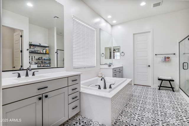 full bath featuring visible vents, a shower stall, a garden tub, and a sink