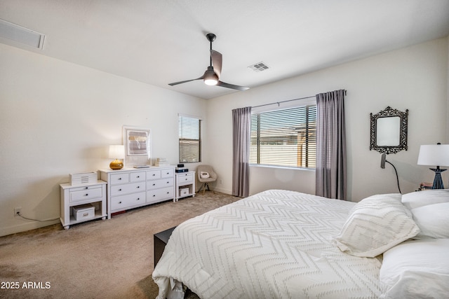 bedroom with baseboards, a ceiling fan, visible vents, and light carpet