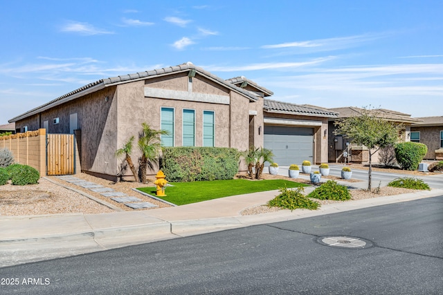 view of front of house featuring fence, stucco siding, concrete driveway, a garage, and a tiled roof