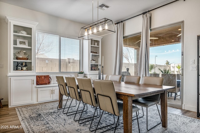 dining area featuring light wood-style flooring and visible vents