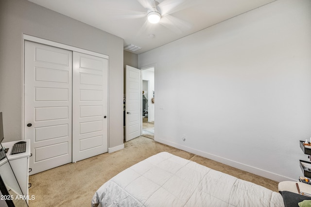 bedroom with light carpet, visible vents, a closet, and baseboards