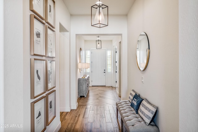 foyer entrance featuring parquet flooring and baseboards