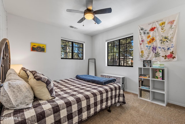 bedroom featuring multiple windows, light colored carpet, and ceiling fan