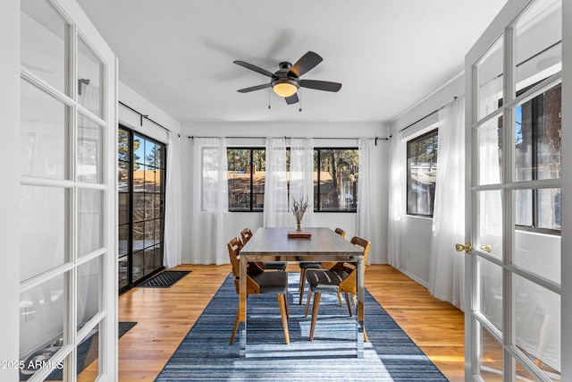 sunroom / solarium featuring french doors, ceiling fan, and a healthy amount of sunlight