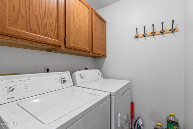 laundry room featuring cabinets and washer and dryer