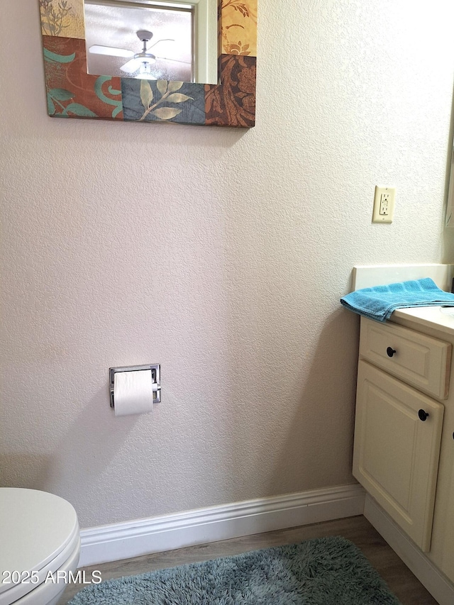 bathroom with hardwood / wood-style floors, vanity, and toilet