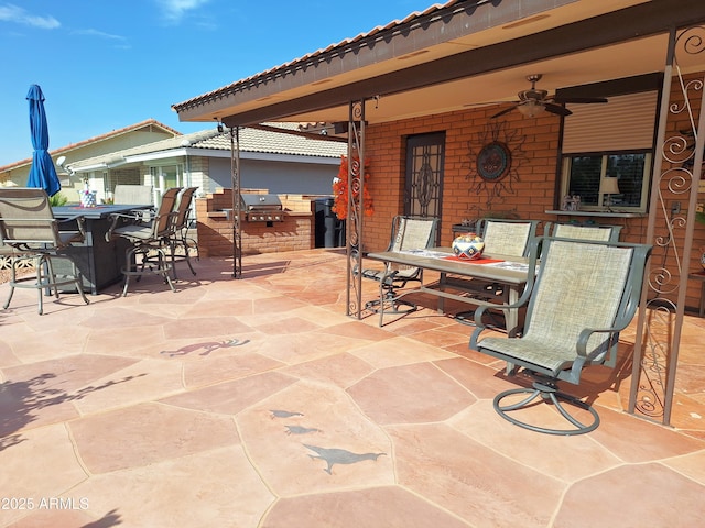 view of patio with ceiling fan, a bar, and an outdoor kitchen