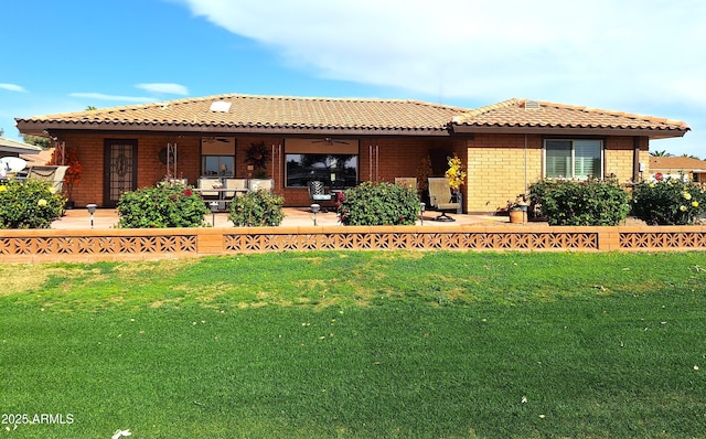 rear view of property with a yard, a patio, and ceiling fan