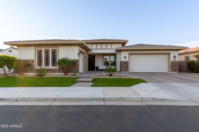 prairie-style home with a garage and a front yard