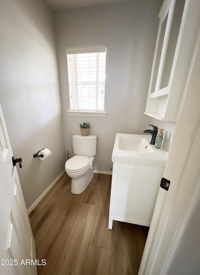 bathroom featuring hardwood / wood-style flooring, vanity, and toilet