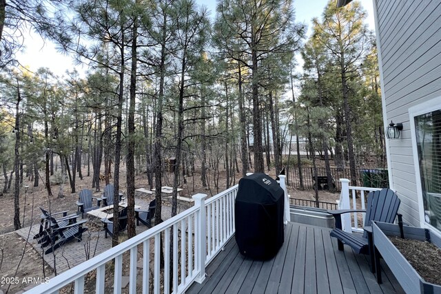 wooden terrace with area for grilling and a fire pit