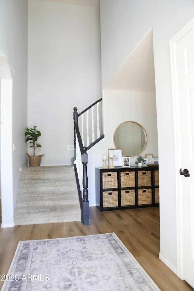 stairway featuring hardwood / wood-style flooring and a towering ceiling