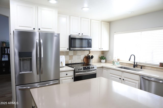 kitchen featuring sink, appliances with stainless steel finishes, white cabinets, and tasteful backsplash