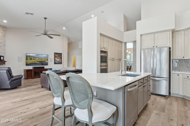 4960 E Dale Ln, Cave Creek, AZ 85331 - kitchen with stainless steel appliances, a sink, open floor plan, light wood-style floors, and high vaulted ceiling
