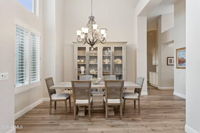 4960 E Dale Ln, Cave Creek, AZ 85331 - dining space featuring a towering ceiling, a chandelier, light wood finished floors, and baseboards