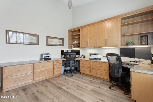 4960 E Dale Ln, Cave Creek, AZ 85331 - home office featuring built in desk, light wood-style flooring, and a towering ceiling