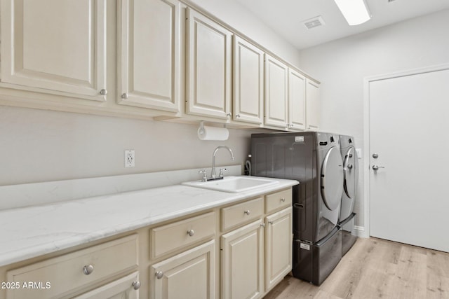 4960 E Dale Ln, Cave Creek, AZ 85331 - laundry area featuring washing machine and clothes dryer, cabinet space, and light wood-style flooring