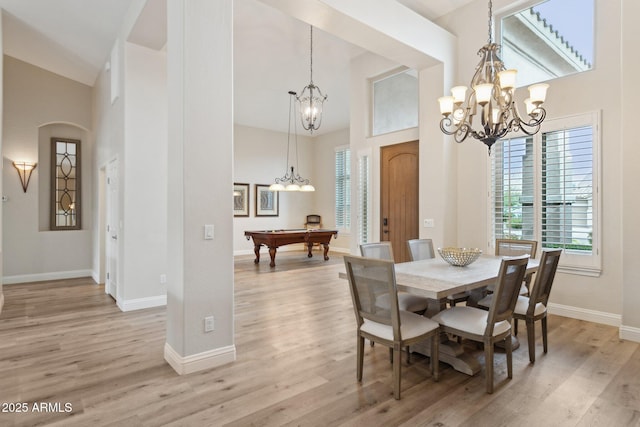 4960 E Dale Ln, Cave Creek, AZ 85331 - dining room featuring a chandelier, a high ceiling, baseboards, light wood-style flooring, and arched walkways