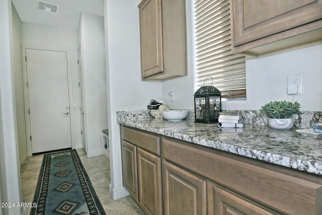 kitchen with light stone counters and light tile patterned floors