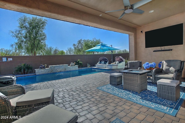 view of pool with a patio area, pool water feature, ceiling fan, and a fire pit