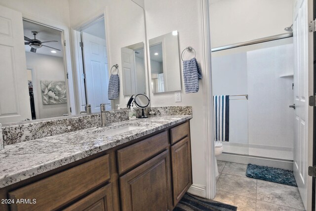 bathroom with ceiling fan, tile patterned floors, an enclosed shower, toilet, and vanity