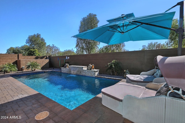 view of swimming pool featuring pool water feature and a patio