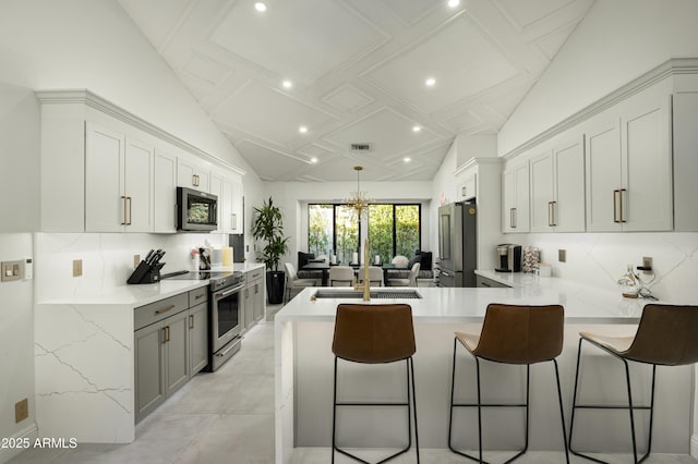 kitchen featuring stainless steel appliances, tasteful backsplash, lofted ceiling, and a kitchen bar