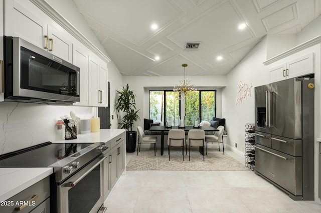 kitchen with stainless steel appliances, white cabinetry, light stone countertops, and pendant lighting