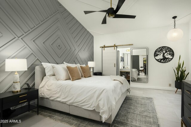 tiled bedroom featuring a barn door and ceiling fan