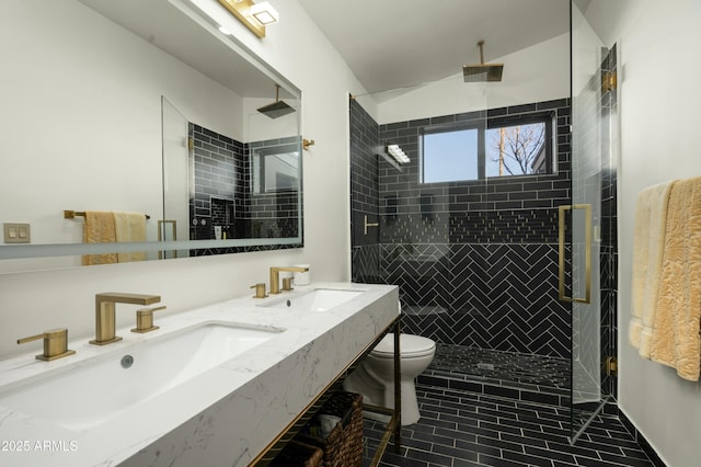 bathroom featuring vanity, toilet, and a tile shower