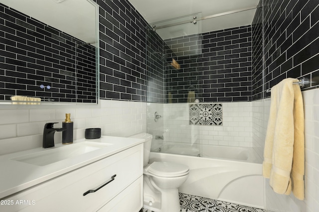 full bathroom featuring tasteful backsplash, tile walls, tiled shower / bath combo, vanity, and toilet