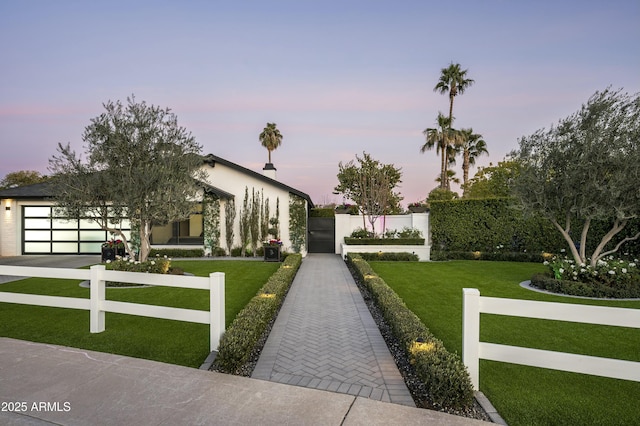 view of front of property with a garage and a yard