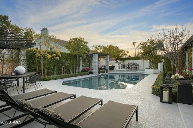 pool at dusk with a patio area