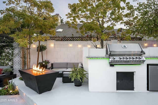 view of patio with an outdoor kitchen, grilling area, and an outdoor fire pit