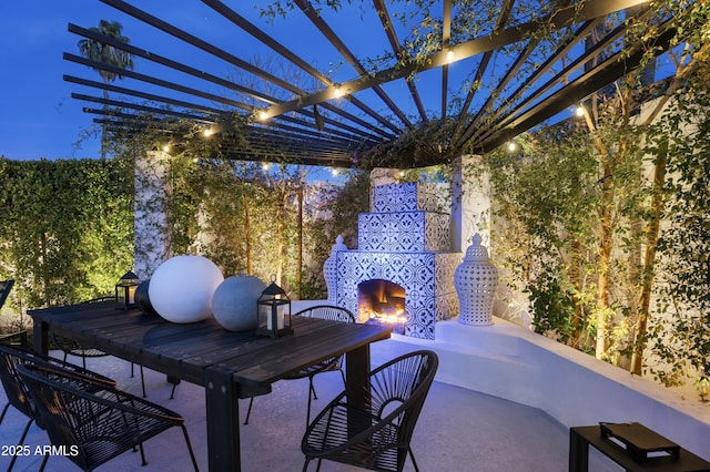 view of patio with exterior fireplace and a pergola