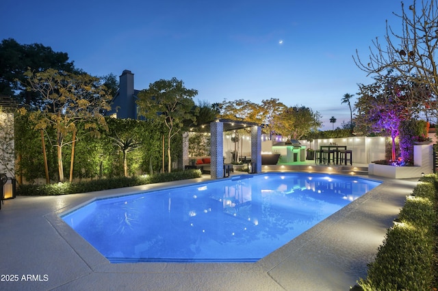 pool at dusk with a patio area