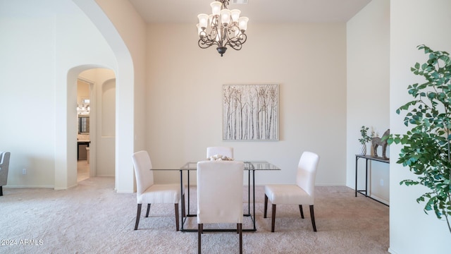 dining area with light carpet and a notable chandelier