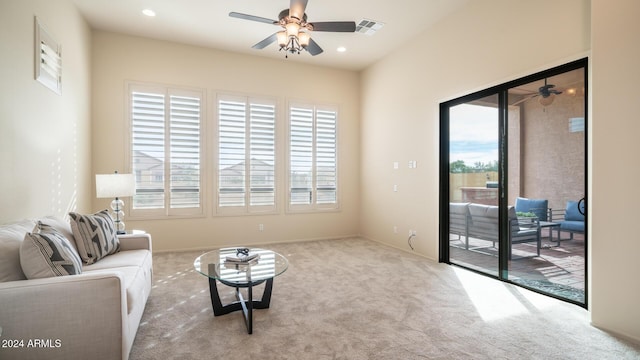 living room with light colored carpet, ceiling fan, and a healthy amount of sunlight