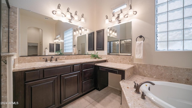 bathroom with tile patterned floors, vanity, and a relaxing tiled tub