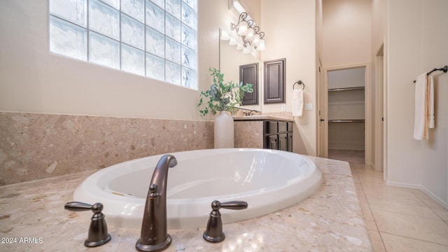 bathroom with tile patterned flooring, vanity, and a bath