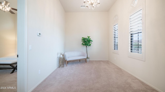 living area with light colored carpet and ceiling fan with notable chandelier