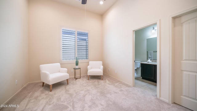 sitting room featuring ceiling fan and light carpet