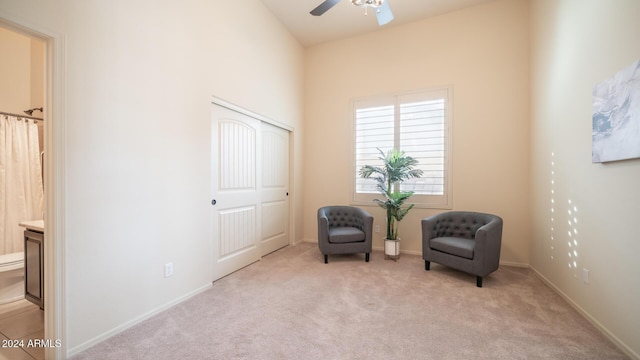 sitting room with light carpet, ceiling fan, and lofted ceiling