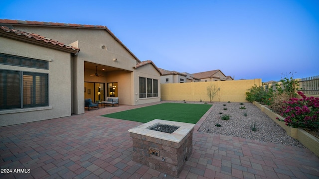 view of patio / terrace with ceiling fan and a fire pit